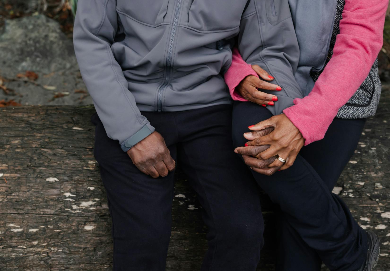 Couple seated holding hands.