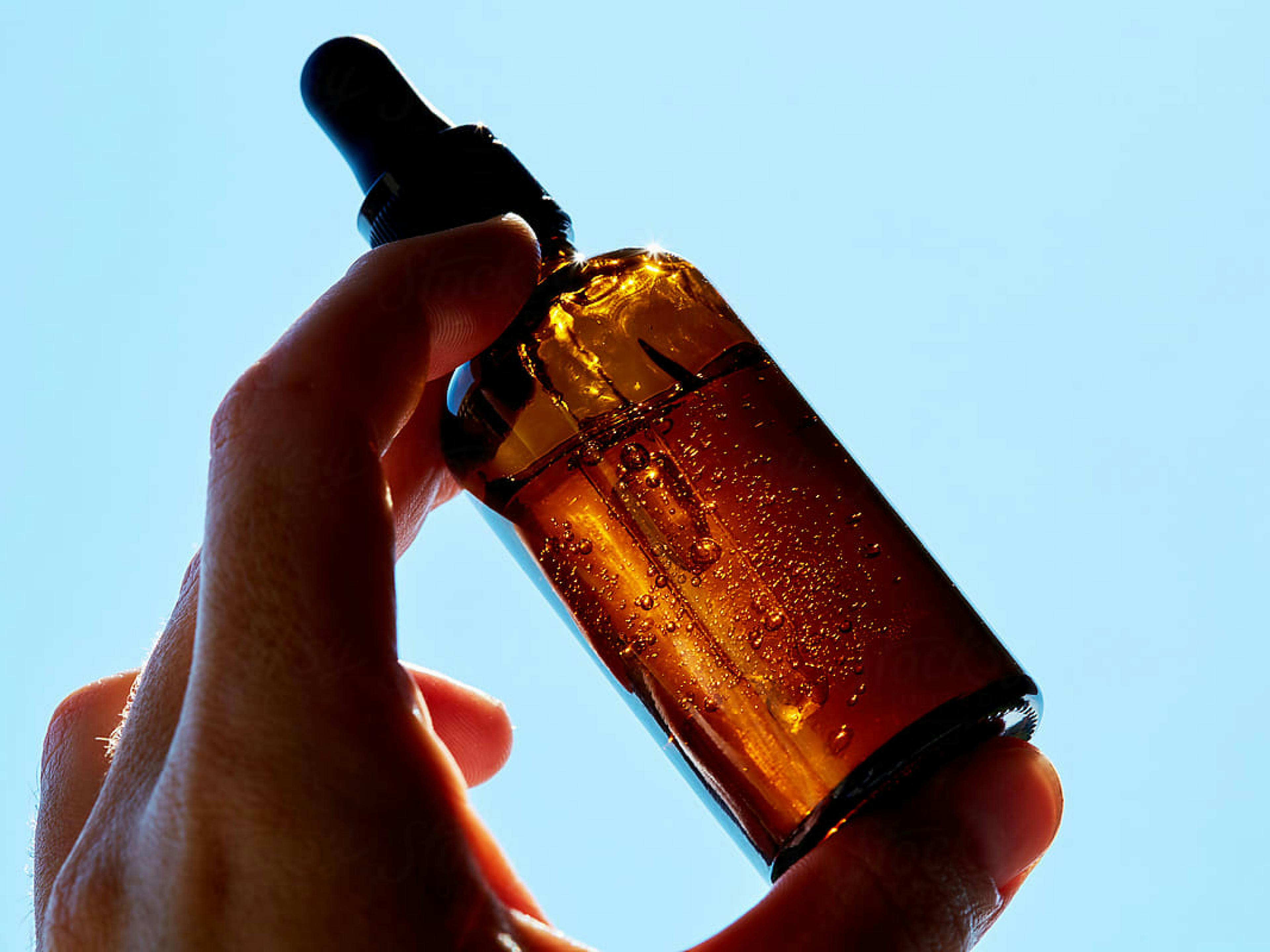 Bottle of serum against a blue background