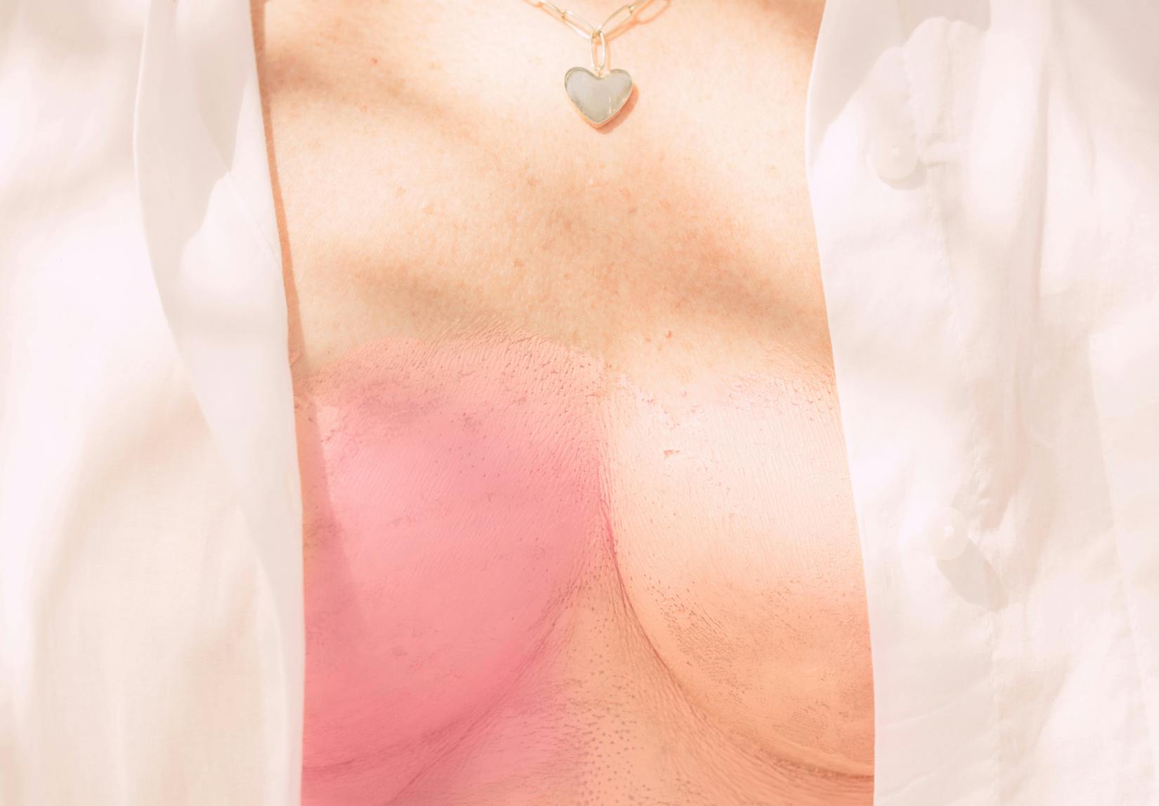 Woman with open shirt; breast painted pink. 